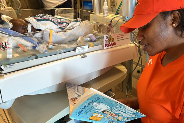 Boura Zerbo Reads a book to her newborn in the ICU.