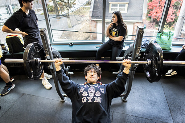 Bryan Yan, a fourth-year finance major in the Wharton School, performs a barbell bench press.