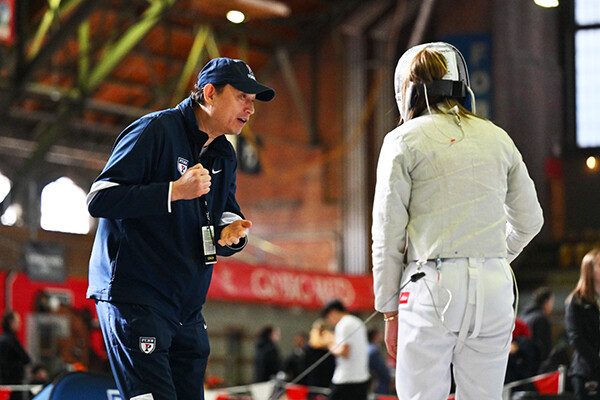 Andy Ma speaks with a fencer during a meet.