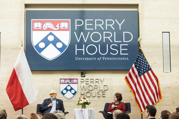 Lech Walesa and Trudy Rubin sit on a stage at Perry World House.