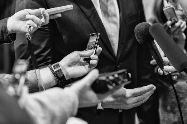 Cropped Hands Of Journalists Interviewing a politician.