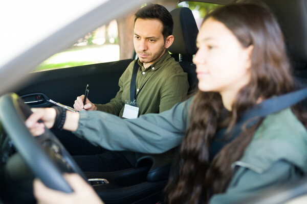 A teen driver with a driving instructor.