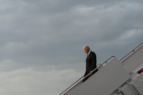 President Joe Biden walks down the Air Force One staircase at sunset.