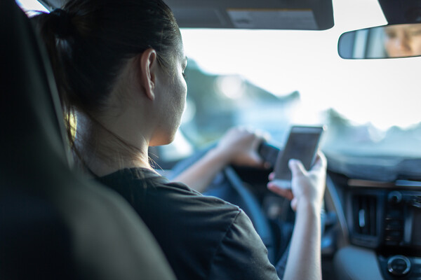 A person texting while driving.
