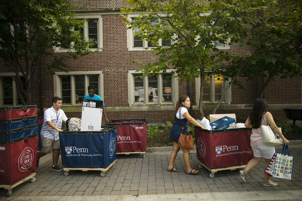 Students pushing Move-In carts outside a Penn dorm.