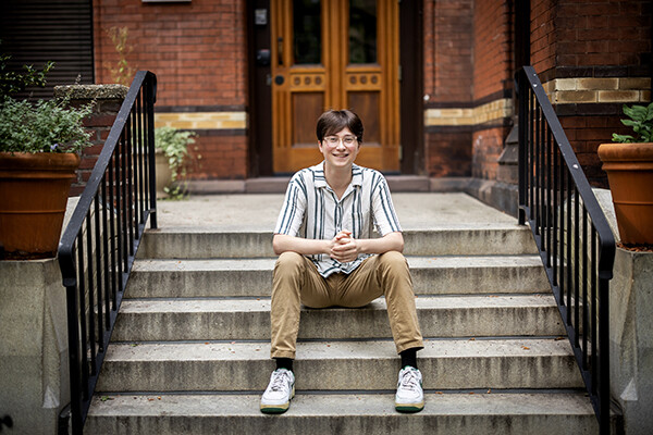 Dylan Fritz sits on the steps outside Penn Press.