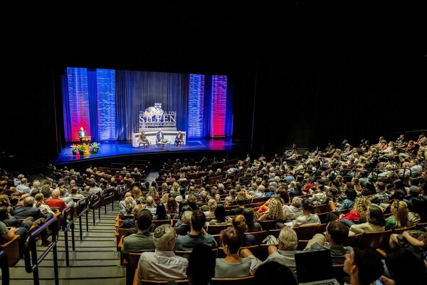 Three panelists on stage and the seated crowd at Penn’s Silfen Forum.