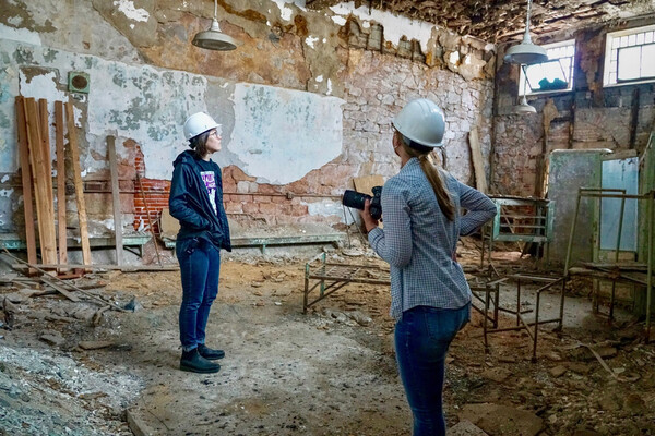 Liz Trumbull and Cameron Moon in the hospital ward of Eastern State Penitentiary, wearing hard hats.