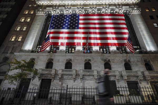 A large American flag hanging on the facade of the New York Stock Exchange.