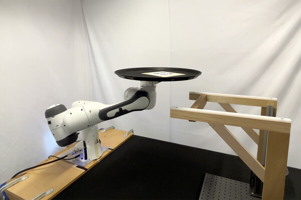 A robotic arm balancing a tray in a lab.