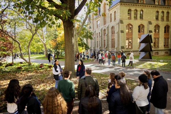 Two students addressing a group of people outside College Hall on College Green.