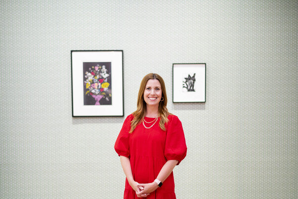 Lynn Dolby standing in front of two artworks