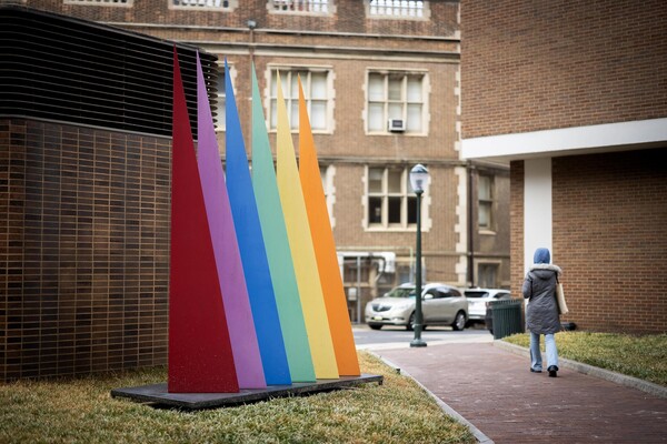 A sculpture of six brightly colored steel triangles points toward the sky.