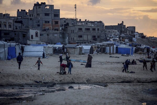 Displaced Palestinians outside their tents near the seaside in Deir al-Balah in the central Gaza Strip.