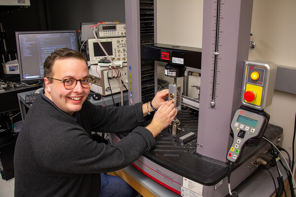 Sage Fulco demonstrates the machine the group used to test the materials’ toughness. 