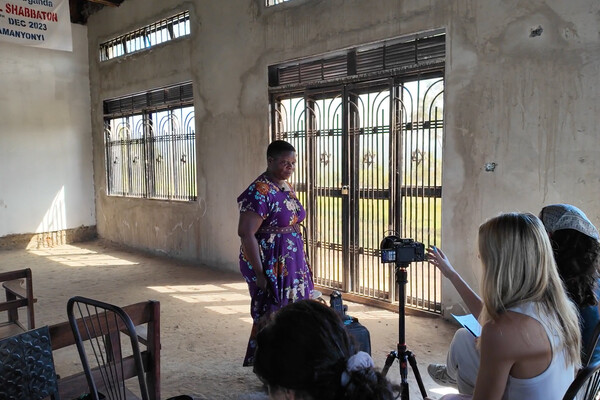 A person being interviewed by Penn students in a Ugandan village.