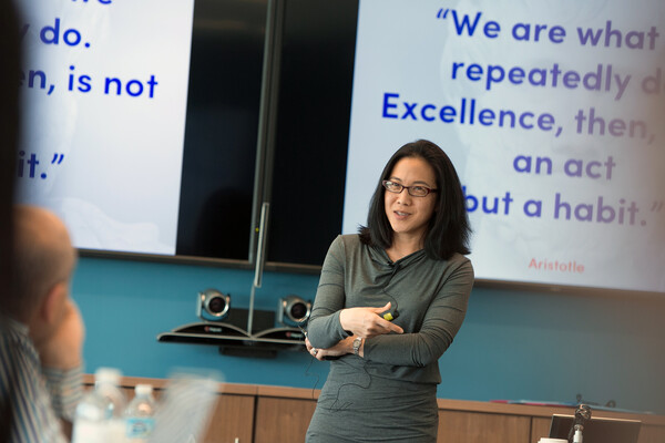 Angela Duckworth lecturing a class with a white board.