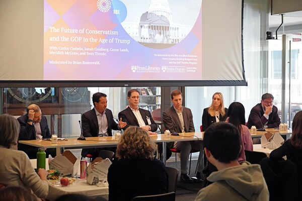 A group of people sits behind a table in a crowded room. A screen behind them reads: “The Future of Conservatism and the GOP in the Age of Trump.”