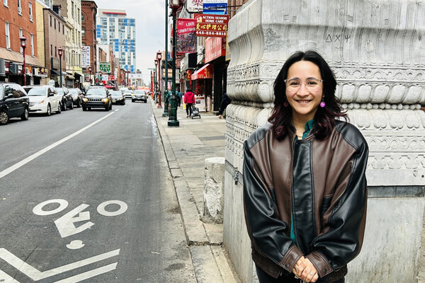 Aki Di Sandro standing on a sidewalk in downtown Philadelphia.