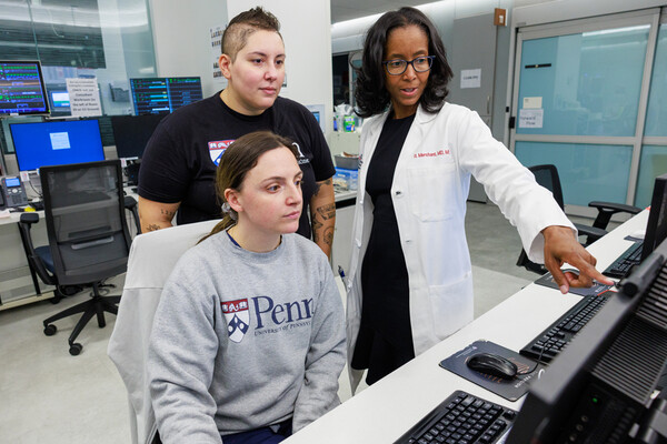Raina Merchant and two staffers in an office looking at a computer at Penn Medicine.