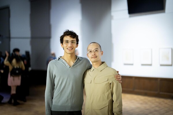 Eissa Attar and Alvin Luong standing in art gallery with arms around each other's shoulders 