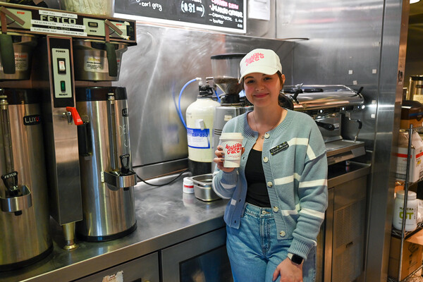 Olivia Turman holding a Williams Cafe coffee cup at the cafe.