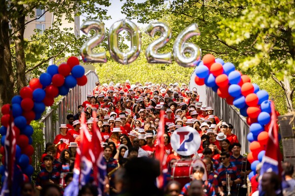 Students walking under a 2026 balloon banner on Locust Bridge during the Hey Day procession.