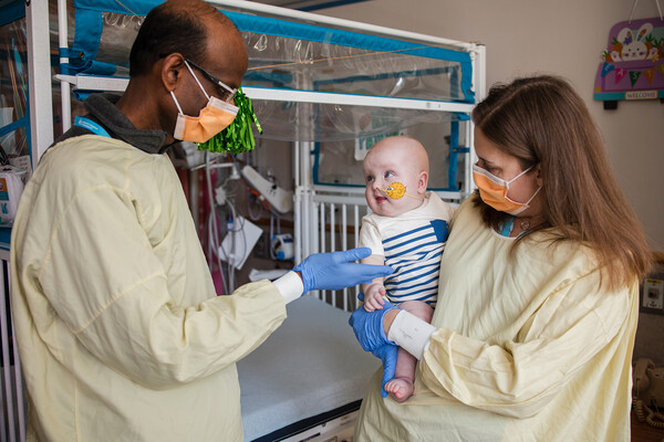 Kiran Musunuru and Rebecca Ahrens-Nicklas holding KJ in the hospital.
