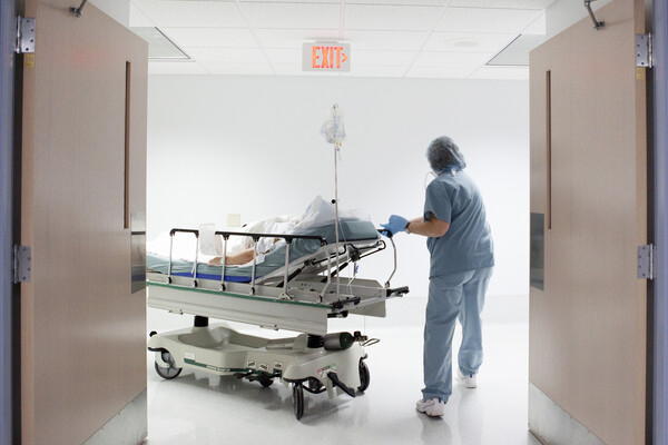 Nurse wheels patient to surgery.