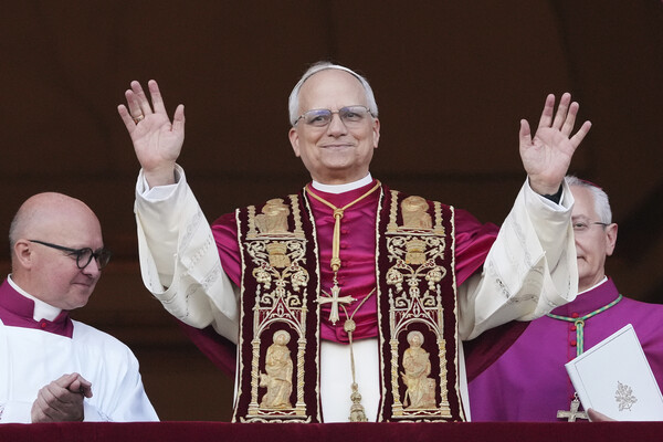 The new pope, Pope Leo, waves from St. Peter’s Basilica.