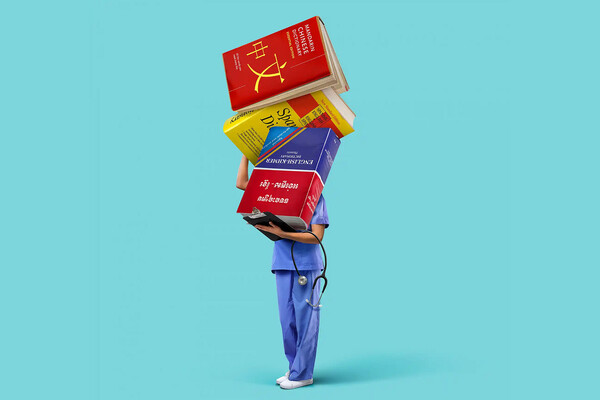 A nurse in scrubs holding oversized foreign language dictionaries.