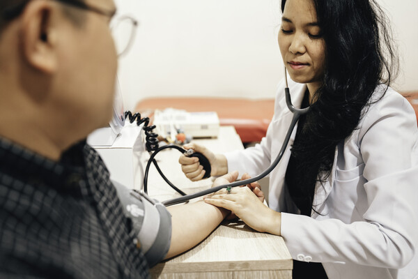 A doctor taking the blood pressure of a patient