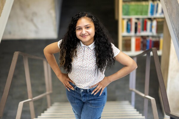 Sierra Williams standing on a stairway in a library. 