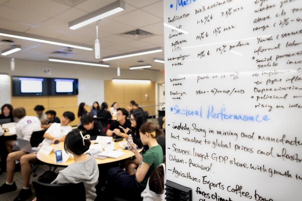 Students in the Economics Academy are seen along with a whiteboard with notes from an earlier project.