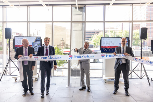 Penn President J. Larry Jameson, Kevin Mahoney and two others cutting a Penn Medicine ribbon at a Ribbon Cutting ceremony.