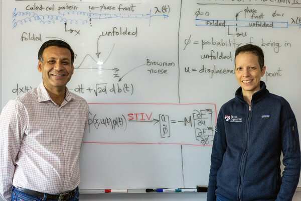 Prashant Purohit (left) and Penn Engineering’s Celia Reina (right) in front of a whiteboard. 