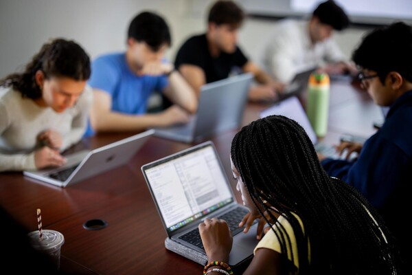 Students work on a pop quiz on their laptops.