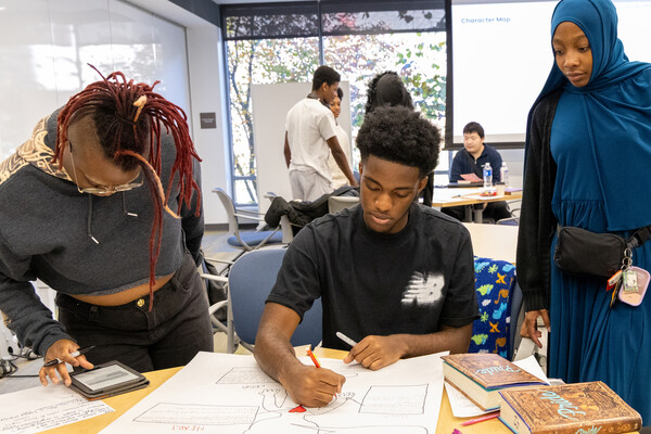 Three students working on a project in a classroom. 