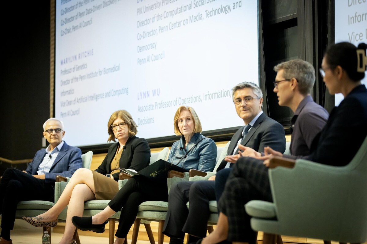 AI Across Disciplines panelists on stage engaged in conversation.