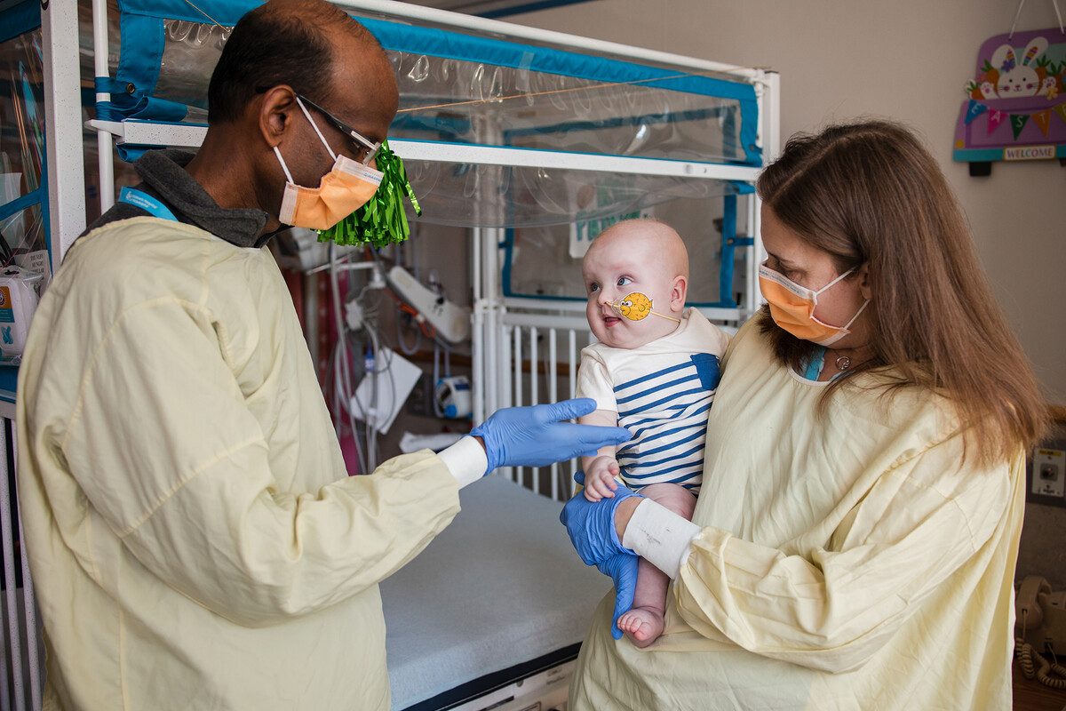 Kiran Musunuru and Rebecca Ahrens-Nicklas holding KJ in the hospital.