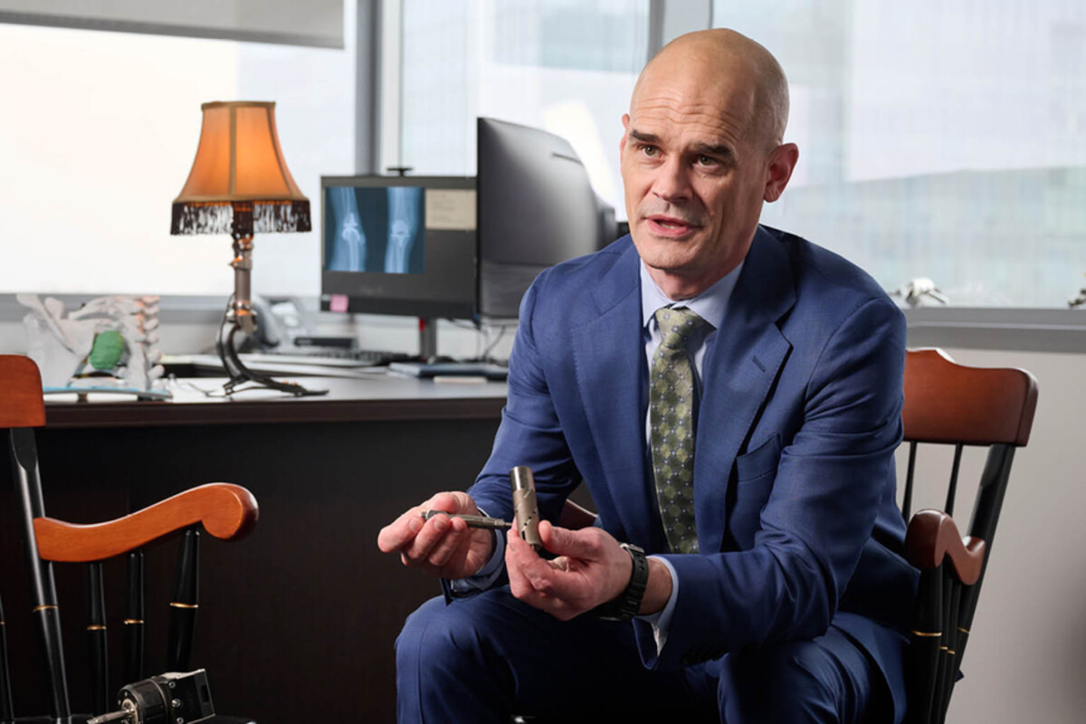 Benjamin Potter holding a piece of prosthetic hardware.