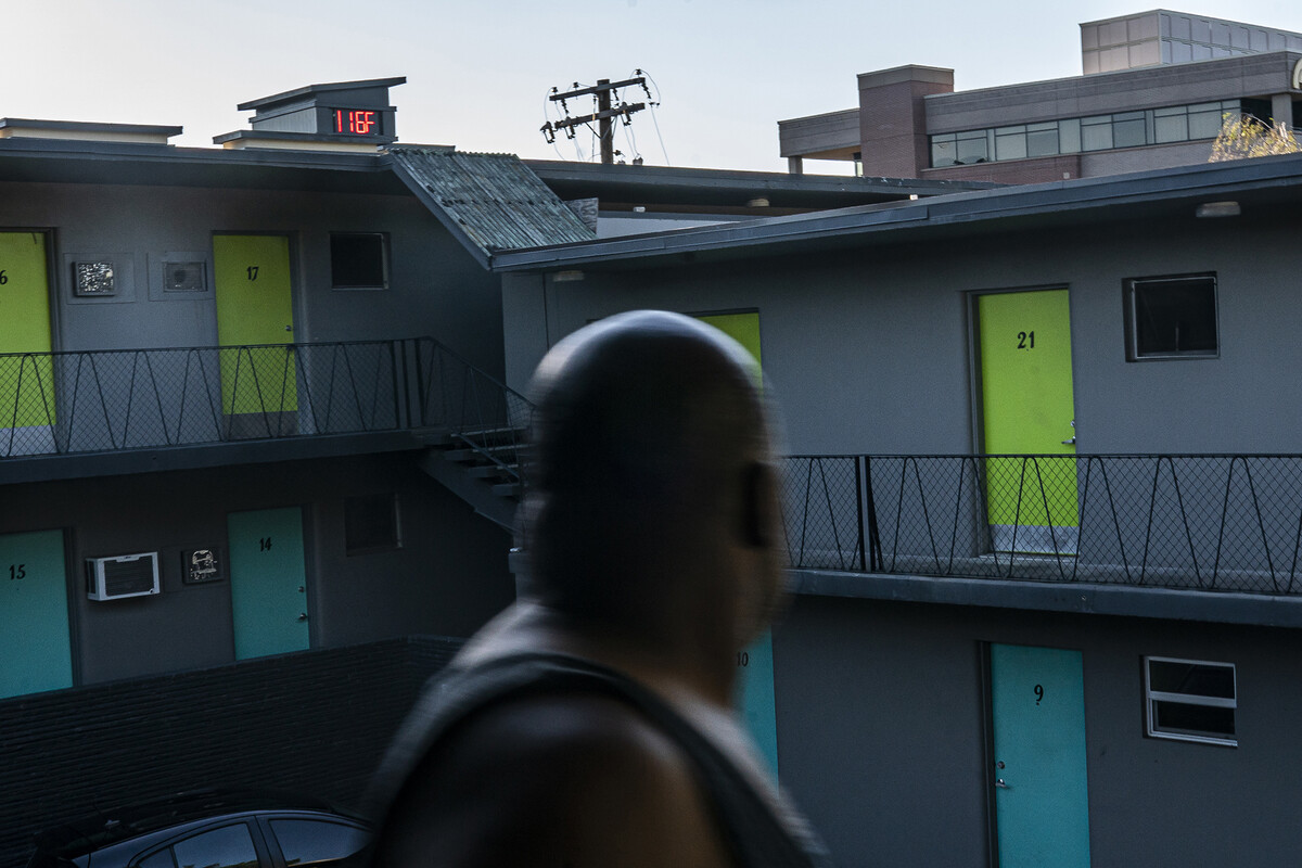 Everett Clayton looks at a digital thermometer on a nearby building that reads 116 degrees while walking to his apartment on June 27, 2021 in Vancouver, Washington.