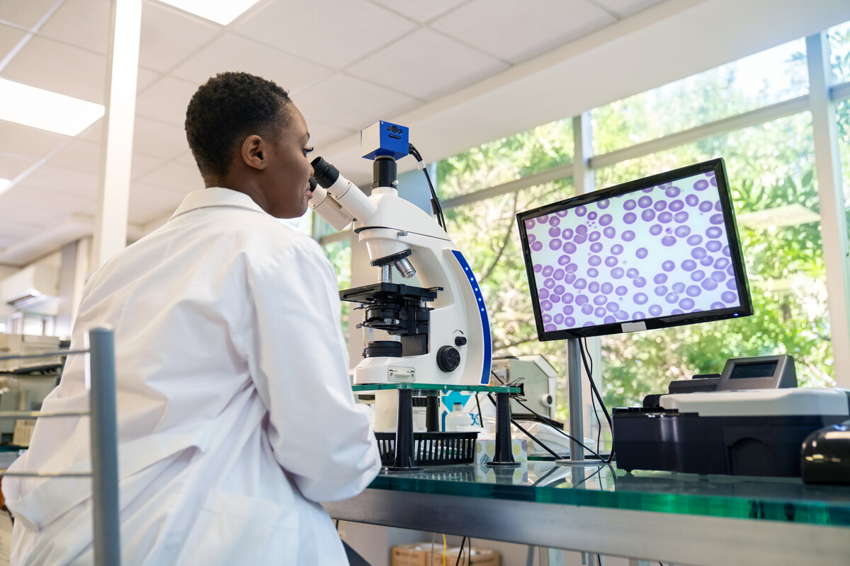 A researcher looking in a microscope.