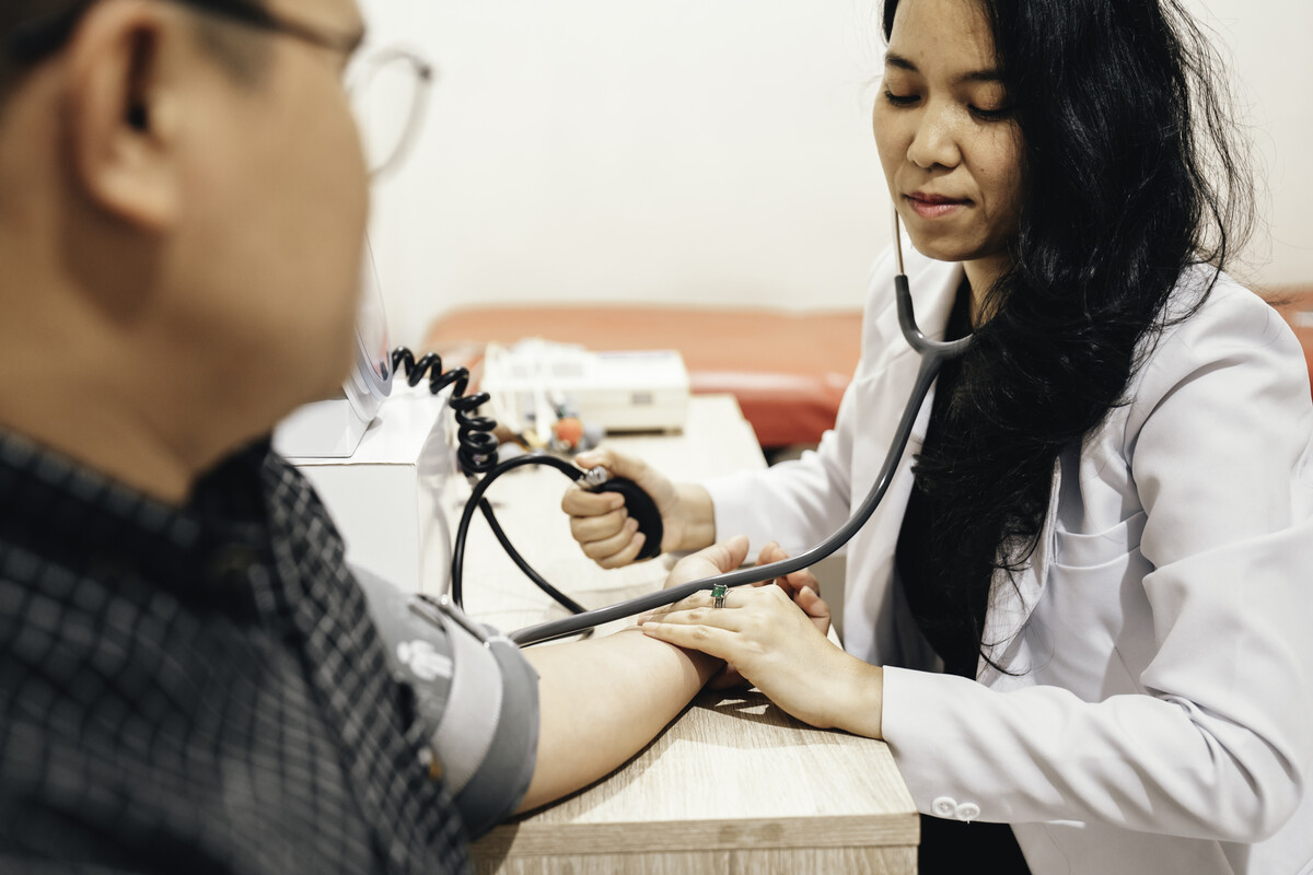 A doctor taking the blood pressure of a patient