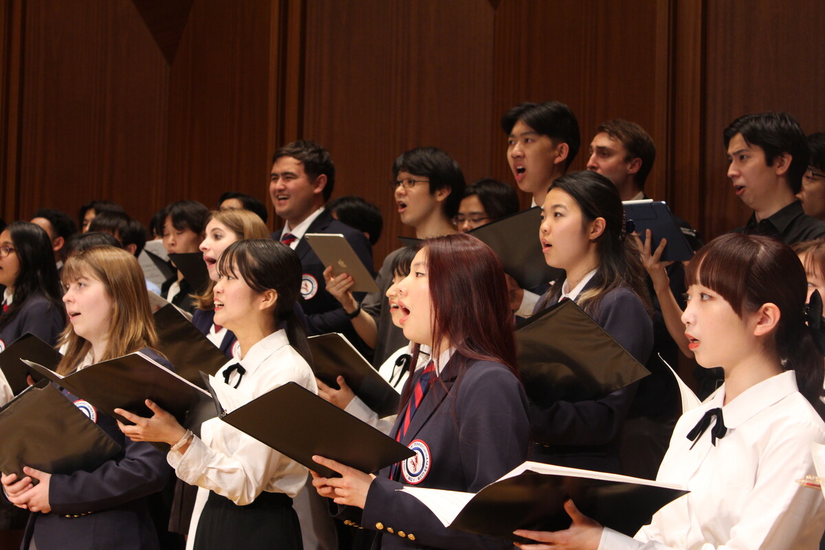 students singing together holding folders