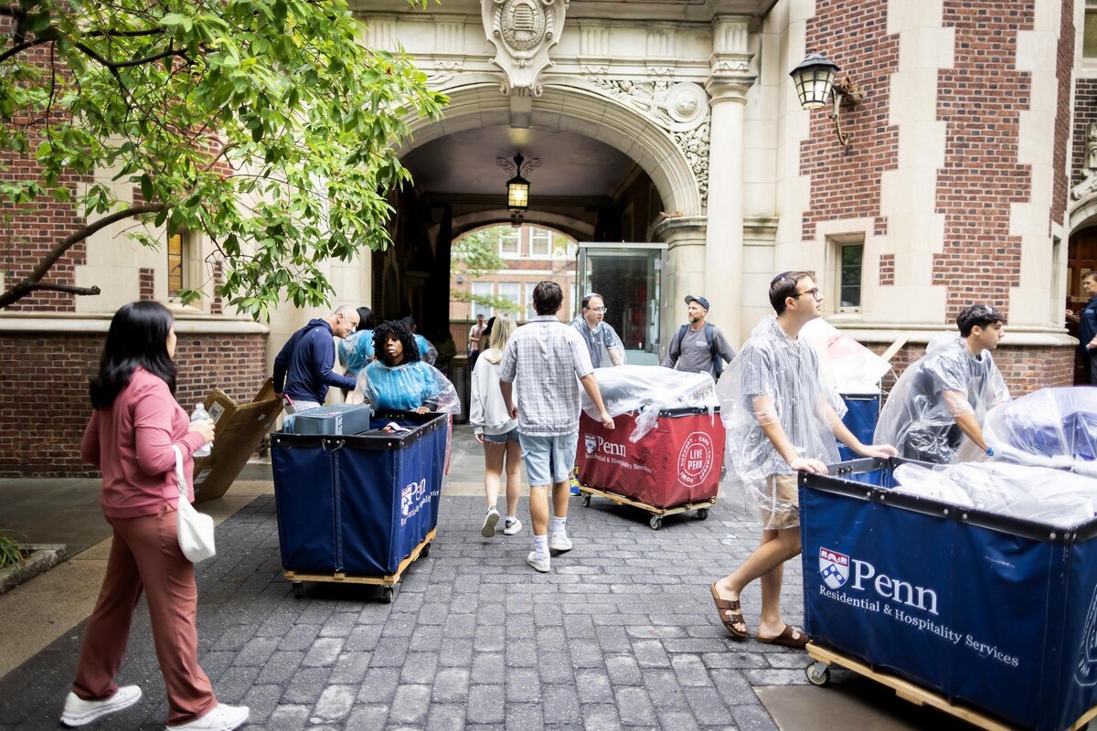 Students and their families outside the Quadrangle during Penn’s Move-In, some pushing Move-In carts.