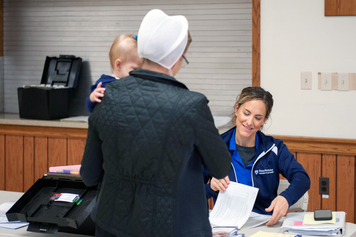 Jennifer N. Carter checks in an Amish patient carrying a child at the Lancaster clinic.