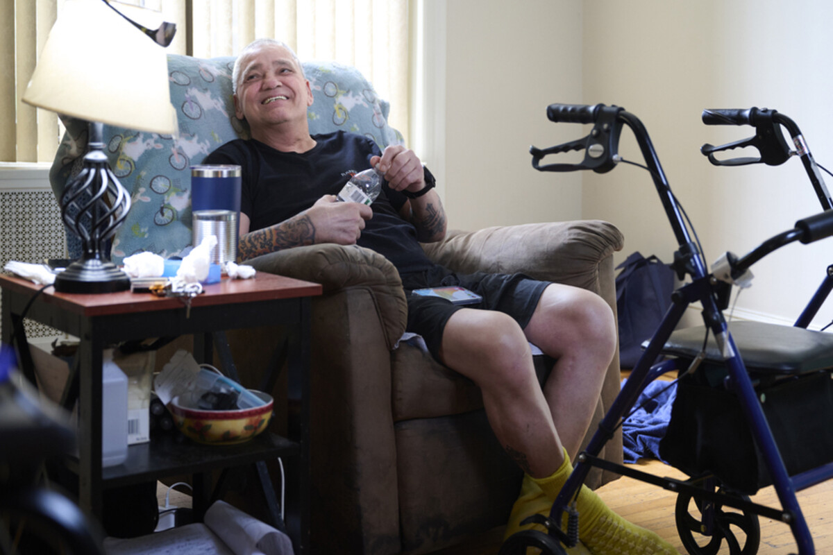 Mike Desalis seated at home next to his walker.
